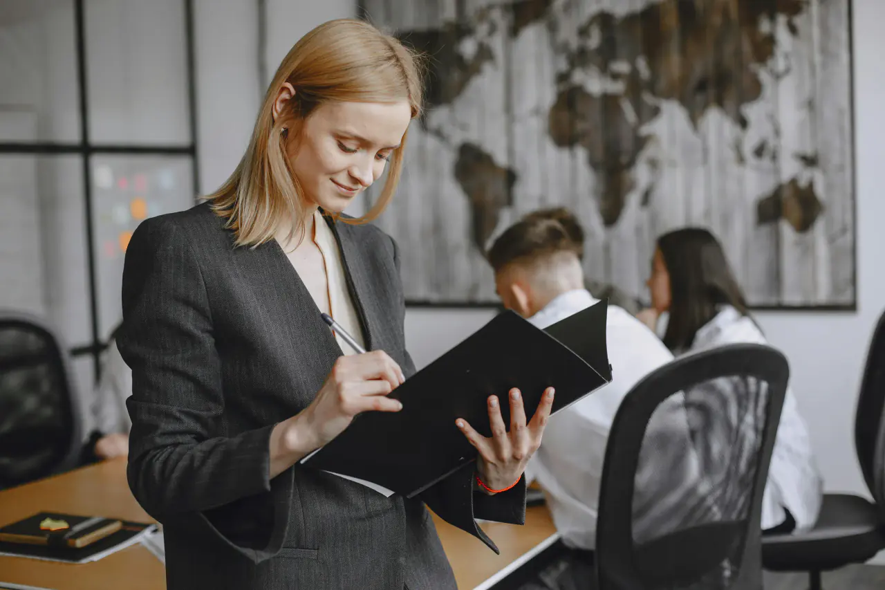 Professional in business attire taking notes in a recruitment setting